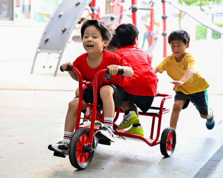 ELC students riding their red tricycle